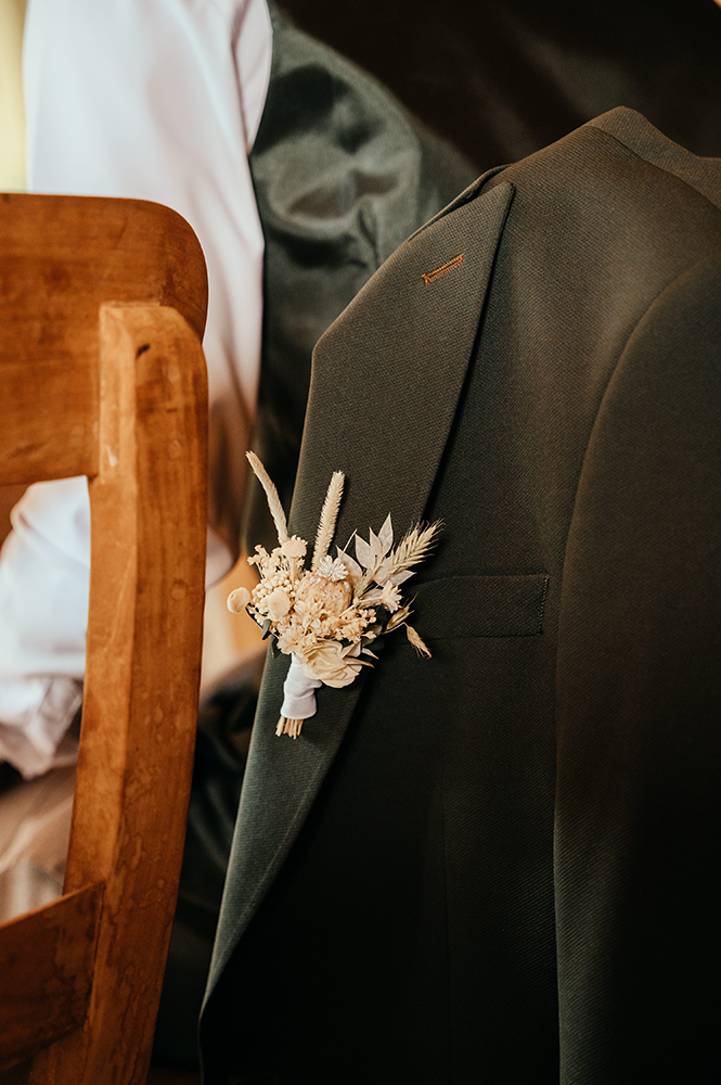 close-up van een corsage op de blazer van de bruidegom-huwelijksfotografie-trouwreportage-byFotografils-IlseWagemakers-Fotograaf gevestigd in Essen