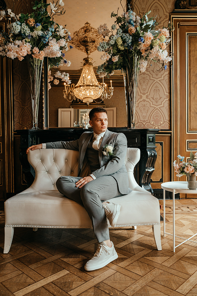 bruidegom poseert al zittend op de ceremonielocatie-huwelijksfotografie-trouwreportage-byFotografils-IlseWagemakers-Fotograaf gevestigd in Essen