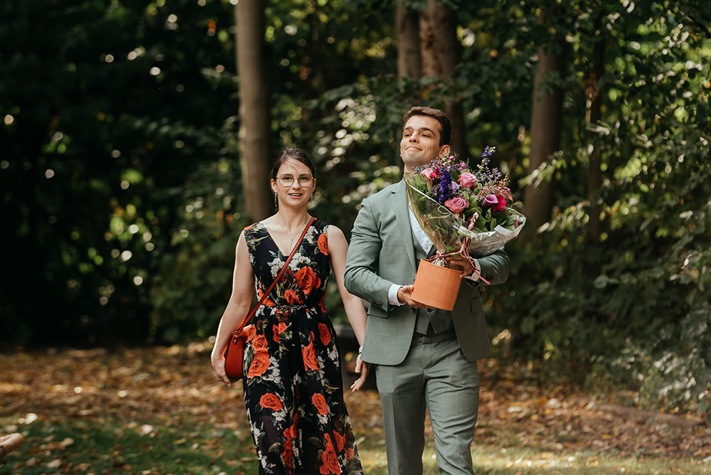 gasten komen aan op het huwelijksfeest met een kleurrijke plant-huwelijksfotografie-trouwreportage-byFotografils-IlseWagemakers-Fotograaf gevestigd in Essen