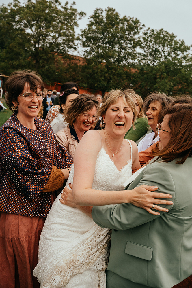 bruid wordt al lachend omhelst door haar vriendinnen-huwelijksfotografie-trouwreportage-byFotografils-IlseWagemakers-Fotograaf gevestigd in Essen