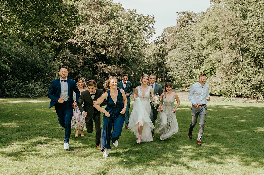 de suite met het bruidspaar komt vrolijk aangerend-huwelijksfotografie-trouwreportage-byFotografils-IlseWagemakers-Fotograaf gevestigd in Essen