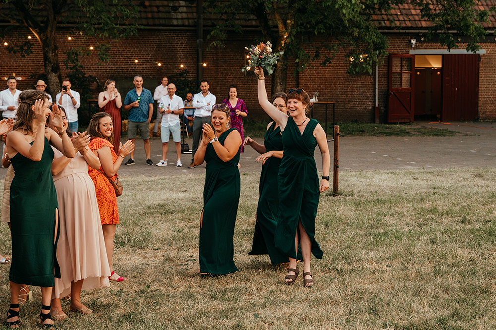 dames van de bruidssuite net na het gooien en vangen van het bruisboeket-huwelijksfotografie-trouwreportage-byFotografils-IlseWagemakers-Fotograaf gevestigd in Essen
