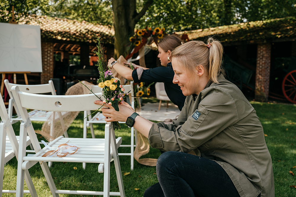 het personeel brengt de laatste bloemendecoratie aan van de ceremoniesetting-huwelijksfotografie-trouwreportage-byFotografils-IlseWagemakers-Fotograaf gevestigd in Essen