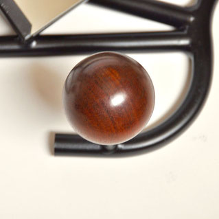 zoom sur patère boule en bois teinte acajou et fixation murale du porte manteau étagère vintage en métal noir