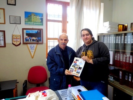 Participant of the project presenting calendar to headmaster of high school of Arta