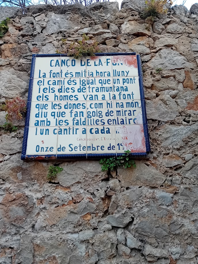 Lied des Brunnens: Der Weg ist eine halbe Stunde (vom Dorf) und wie eine Brücke. An Tramuntana-Tagen kommen die Männer zum Brunnen, weil es eine Freude ist,  Frauen anzuschauen - wie die Welt sagt - mit hochgeschürzten Röcken und einen Krug in jeder Hand.