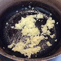 鍋にオリーブオイルとニンニク、玉ねぎを入れて火を付け、玉ねぎがしんなりするまで炒める。