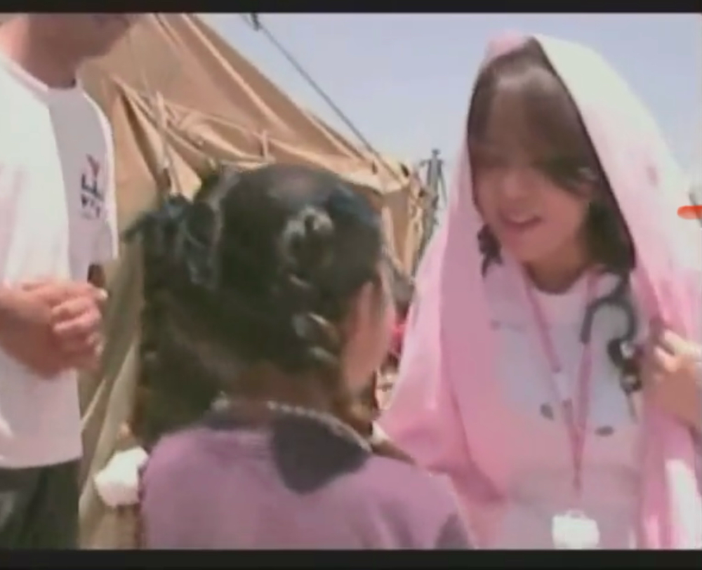 イラク難民キャンプで難民の女の子と握手するユカリ医師