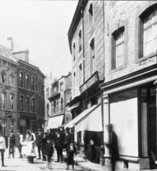 Oude foto van de Limbrichterstraat, met rechts de nog ongepleisterde gevel en winkelpui van nummer 55 en de oorspronkelijke één as brede opzet van nummer 57 (bron: beeldbank De Domeinen).