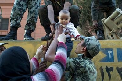 An Egyptian woman takes her son back after taking a picture of him with soldiers at Cairo’s Tahrir Square on Sunday (AFP photo by Pedro Ugarte)