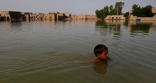A flood victim wades through floodwaters while he leaves his village of Bello Patan for higher ground in Dadu, some 320 kilometres (198 miles) north of Karachi, September 13, 2010. – Reuters