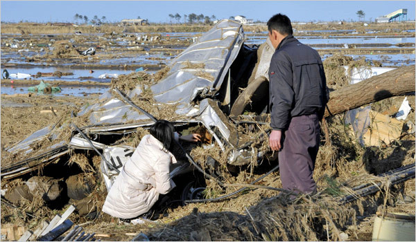 Parents look at the body of their daughter they found in the vehicle of a driving school in Yamamoto, Miyagi Prefecture