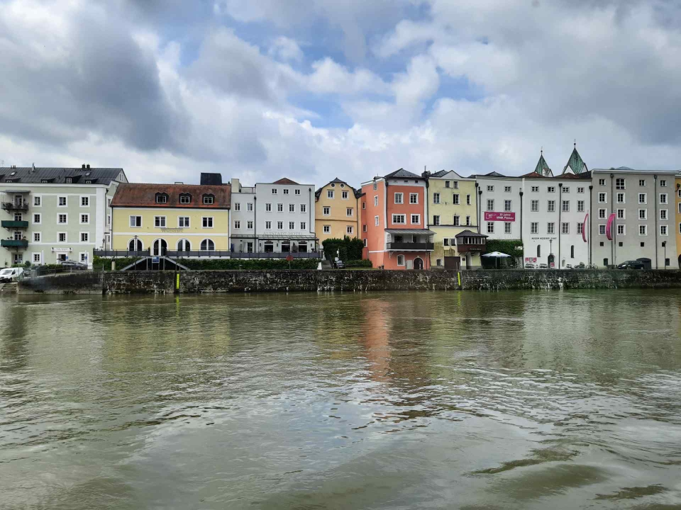 Spiegelung der bunten Altstadt-Fassaden im ruhigen Wasser der Donau