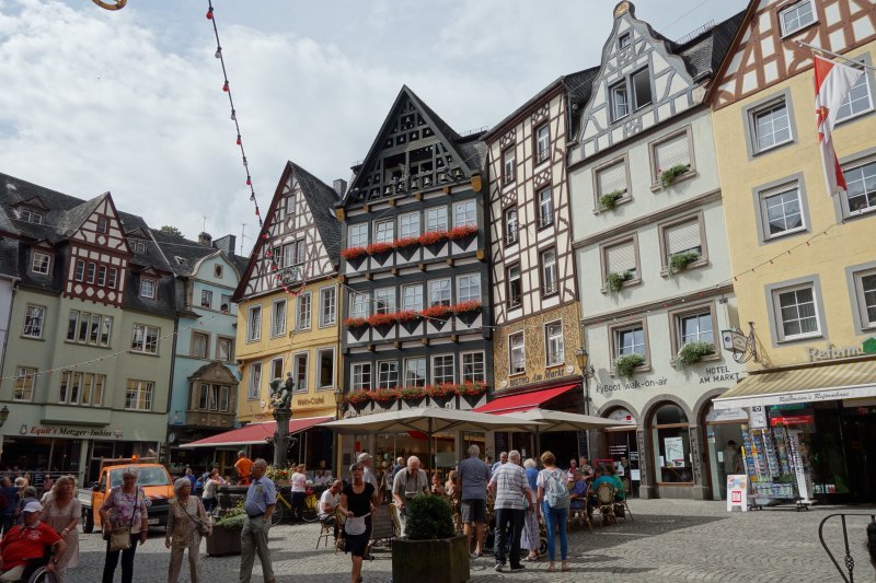 Belebter Platz in Cochem mit Außengastronomie und historischen Fassaden