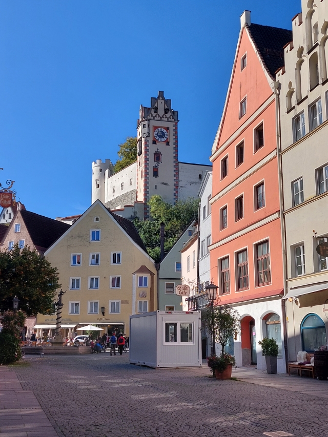 Blick durch eine schmale Gasse der Füssener Altstadt auf das Hohe Schloss