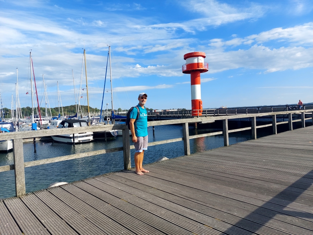 Blick auf den Hafen von Eckernförde mit Segelbooten und dem rot-weißen Leuchtturm.