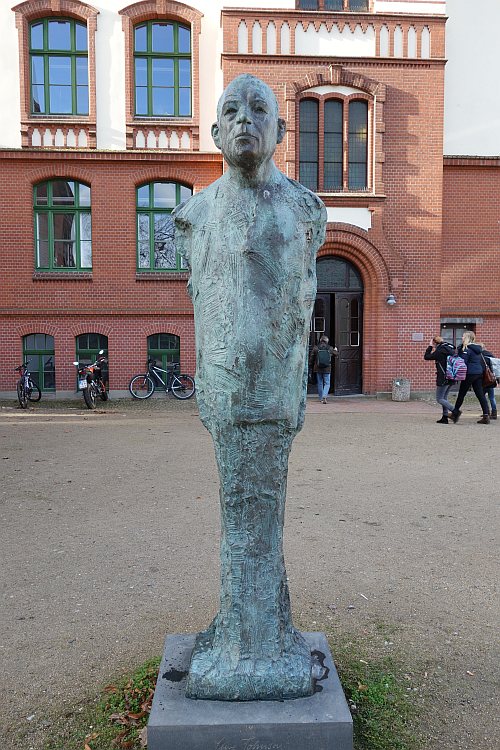 Skulptur von Uwe Johnson vor dem John-Brinckman-Gymnasium. 