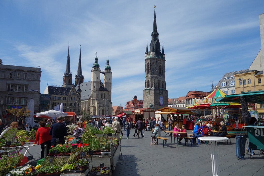 Blick über den belebten Marktplatz von Halle auf den Roten Turm und die Marktkirche