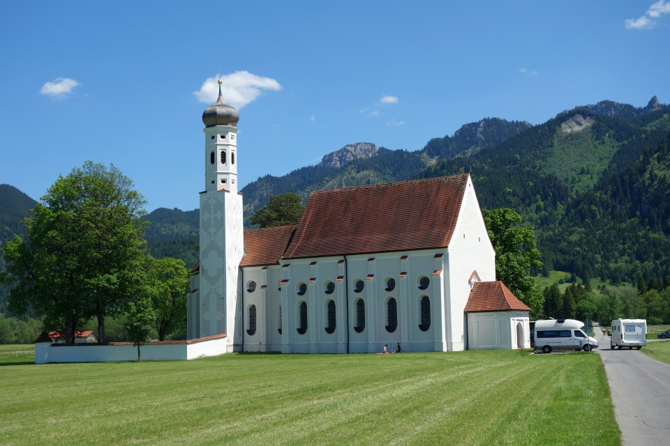 Die barocke Kirche St. Coloman im Tal vor der gewaltigen Tegelbergwand