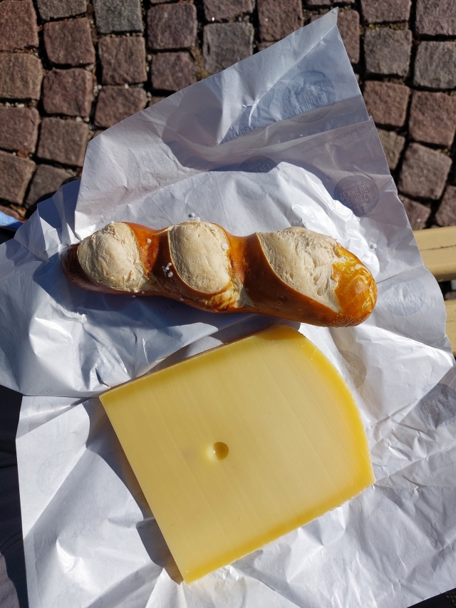 Nahaufnahm zwei aufgeschnittenen Brötchen und einem großen Stück Bergkäse