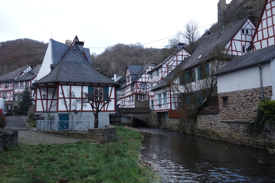 Eine schmale, kopfsteingepflasterte Gasse, die sich zwischen den Fachwerkhäusern entlang der Elz windet