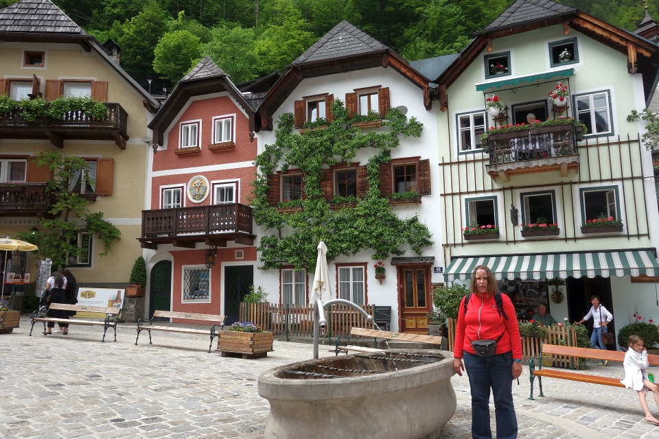 Historische Fachwerkhäuser am zentralen Marktplatz von Hallstatt mit Brunnen