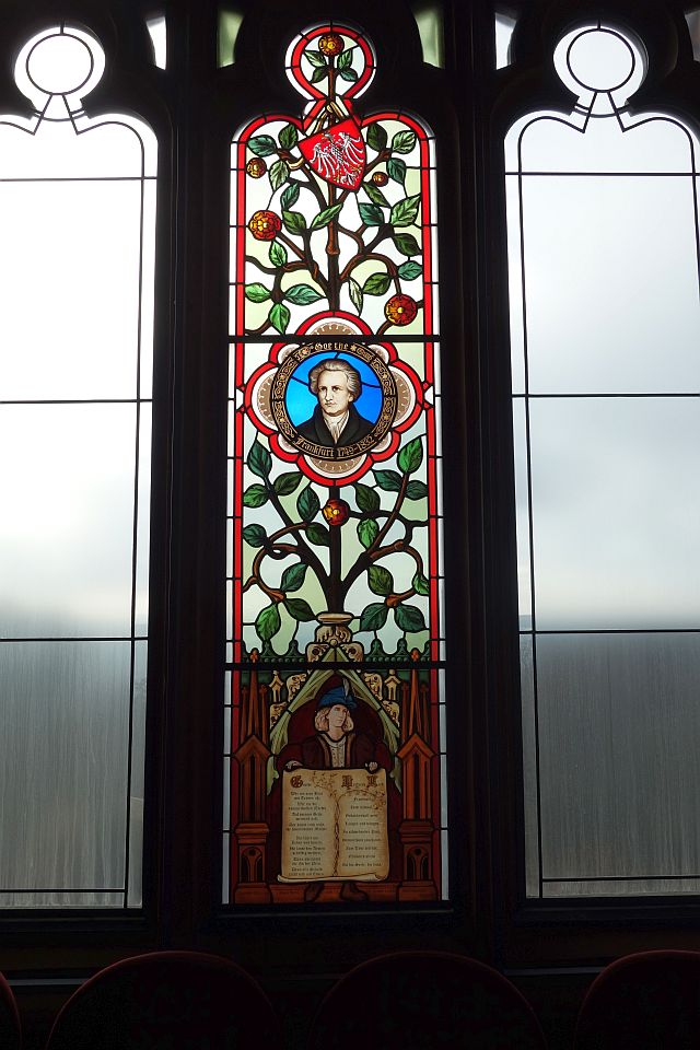 Detailreiches, buntes Kirchenfenster mit religiösen Motiven in der Schlosskapelle