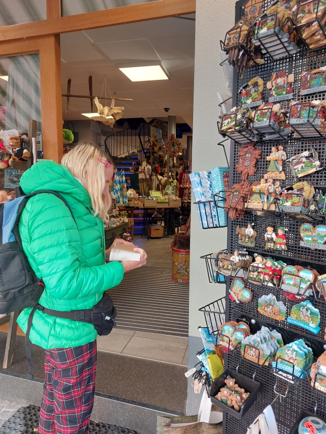 Christina betrachtet Souvenirs in einem Laden in Füssen