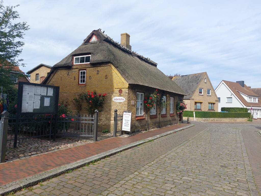 Ein traditionelles Reetdachhaus in Maasholm unter blauem Himmel