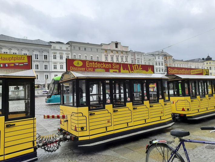 Eine gelbe Bergbahn (Pöstlingbergbahn) steht abfahrtsbereit an der Haltestelle