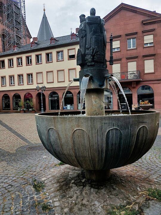 Der Marktschifffahrtsbrunnen auf dem belebten Mainzer Marktplatz vor historischer Kulisse