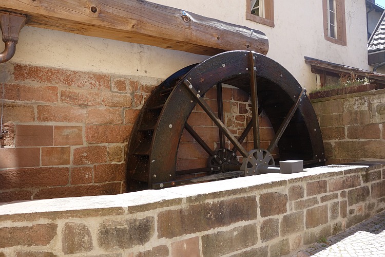 Ein altes, hölzernes Mühlrad, das an die Geschichte des Handwerks in der Region erinnert