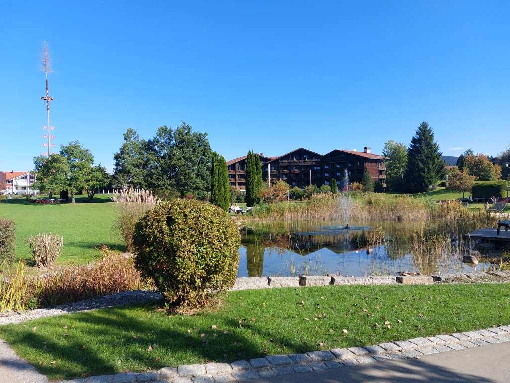 Blick auf eine Parkanlage mit einem kleinen See und modernen Skulpturen in Oberstaufen