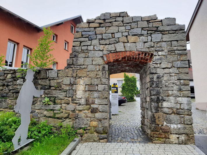 Blick durch ein steinernes Tor auf eine historische Häuserzeile in Waldkirchen