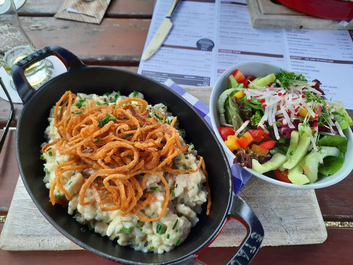 Ein Teller mit frisch zubereiteten Käsespätzle und Beilagensalat Oberhaus