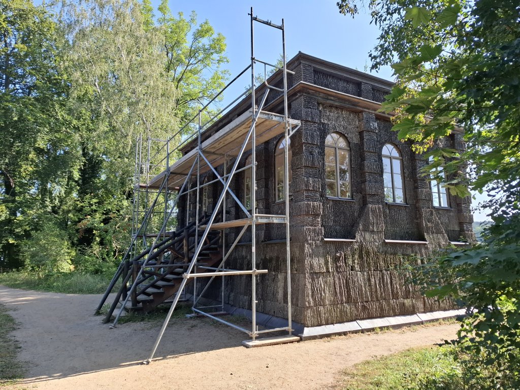 Ein rustikales, mit Holz verschaltes Gebäude, das derzeit renoviert wird