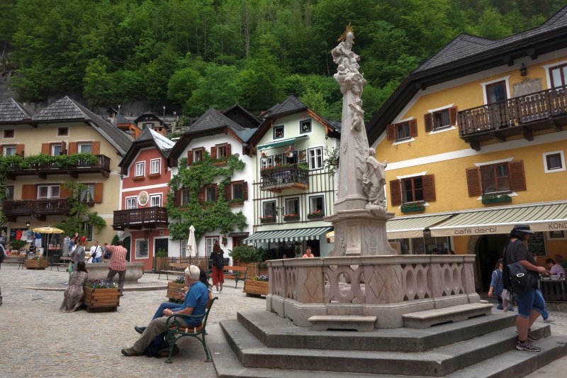 Der historische Marktplatz von Hallstatt mit der Dreifaltigkeitssäule und umliegenden Cafés