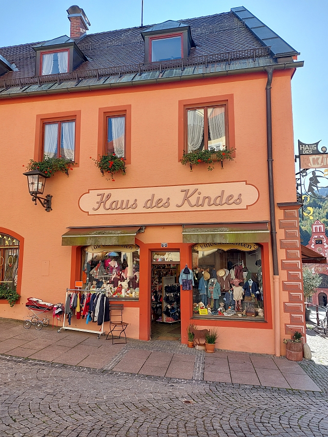 Ein charmantes, orangefarbenes Haus mit Blumenkästen in der Fußgängerzone