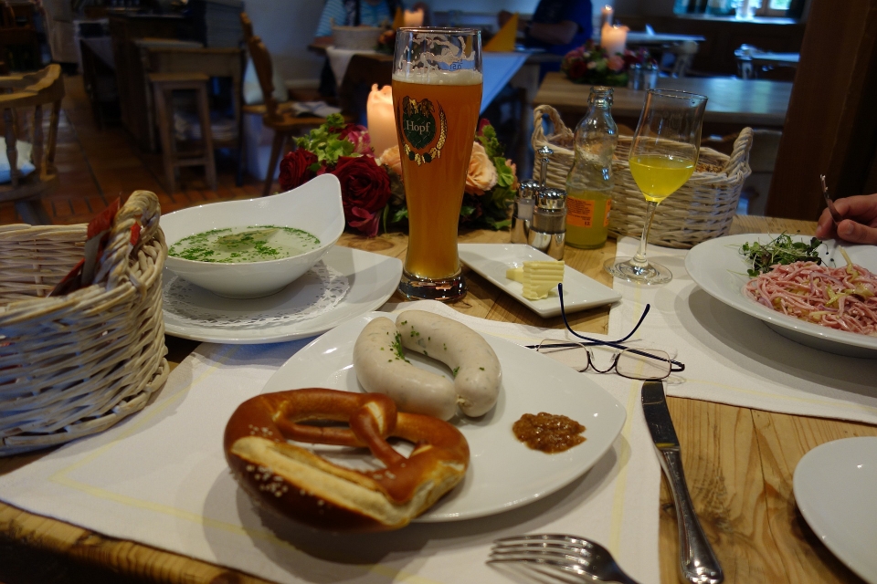 Ein gedeckter Tisch mit traditionellen bayerischen Speisen in einer gemütlichen Gaststube