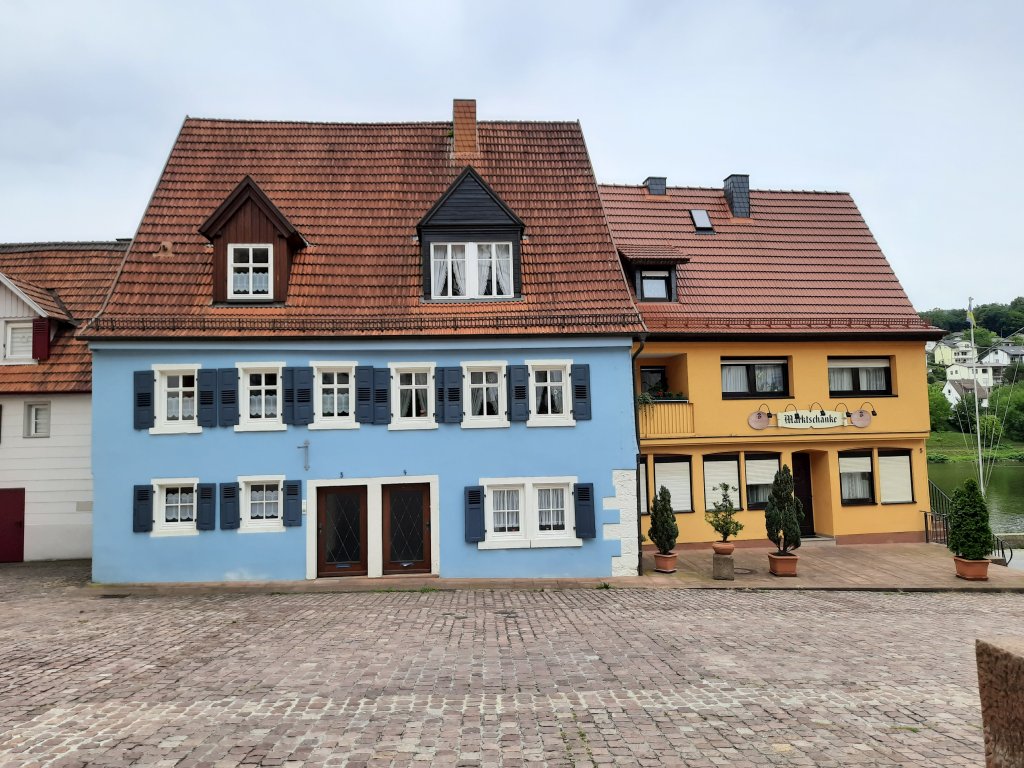 Ein markantes, hellblau gestrichenes Fachwerkhaus an einem gepflasterten Platz in der Altstadt.