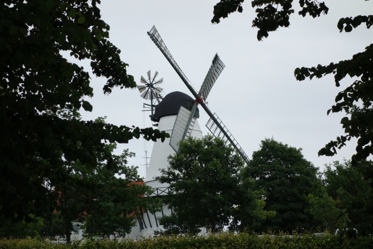 Die historische weiße Düppeler Mühle vor grauem Himmel