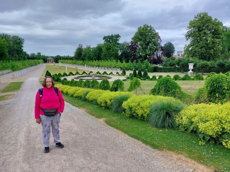 Ein Spazierweg führt durch die gepflegte Parkanlage des Schlossgartens mit Blick auf grüne Hecken und Rasenflächen