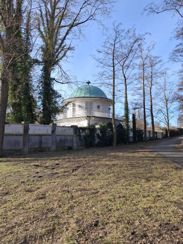 Die historische Villa Lemm in Gatow mit ihrer markanten grünen Kuppel und weißer Fassade unter blauem Himmel
