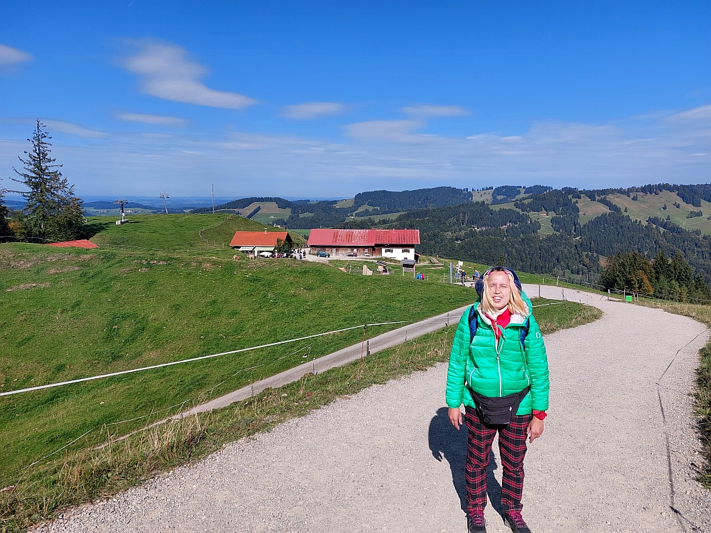 Christina wandert auf einem schmalen Pfad über eine sonnige Bergwiese