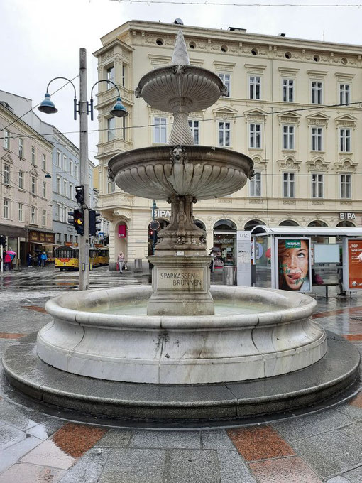 Der barocke Brunnen auf dem Linzer Hauptplatz vor historischer Kulisse