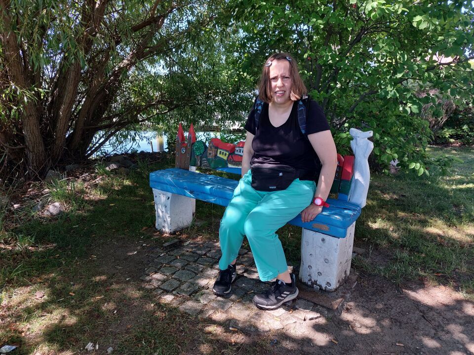 Person auf einer Bank am Neuruppiner See entspannend