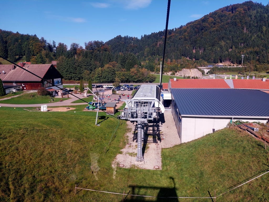 Blick auf die Bergstation der Hündlebahn mit sommerrodelbahn-Elementen und Wanderern