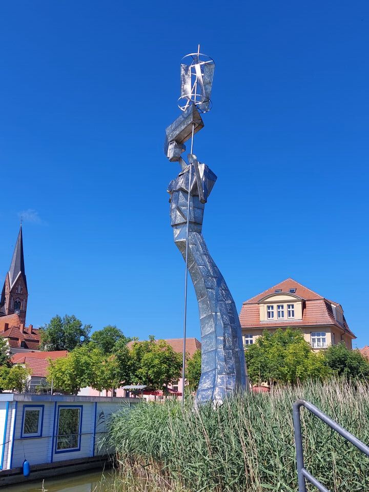 Skulptur im öffentlichen Raum vor historischer Kulisse