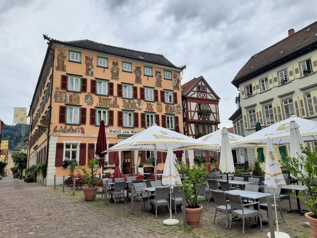 Ein gemütlicher, gepflasterter Platz mit Außengastronomie und Sonnenschirmen
