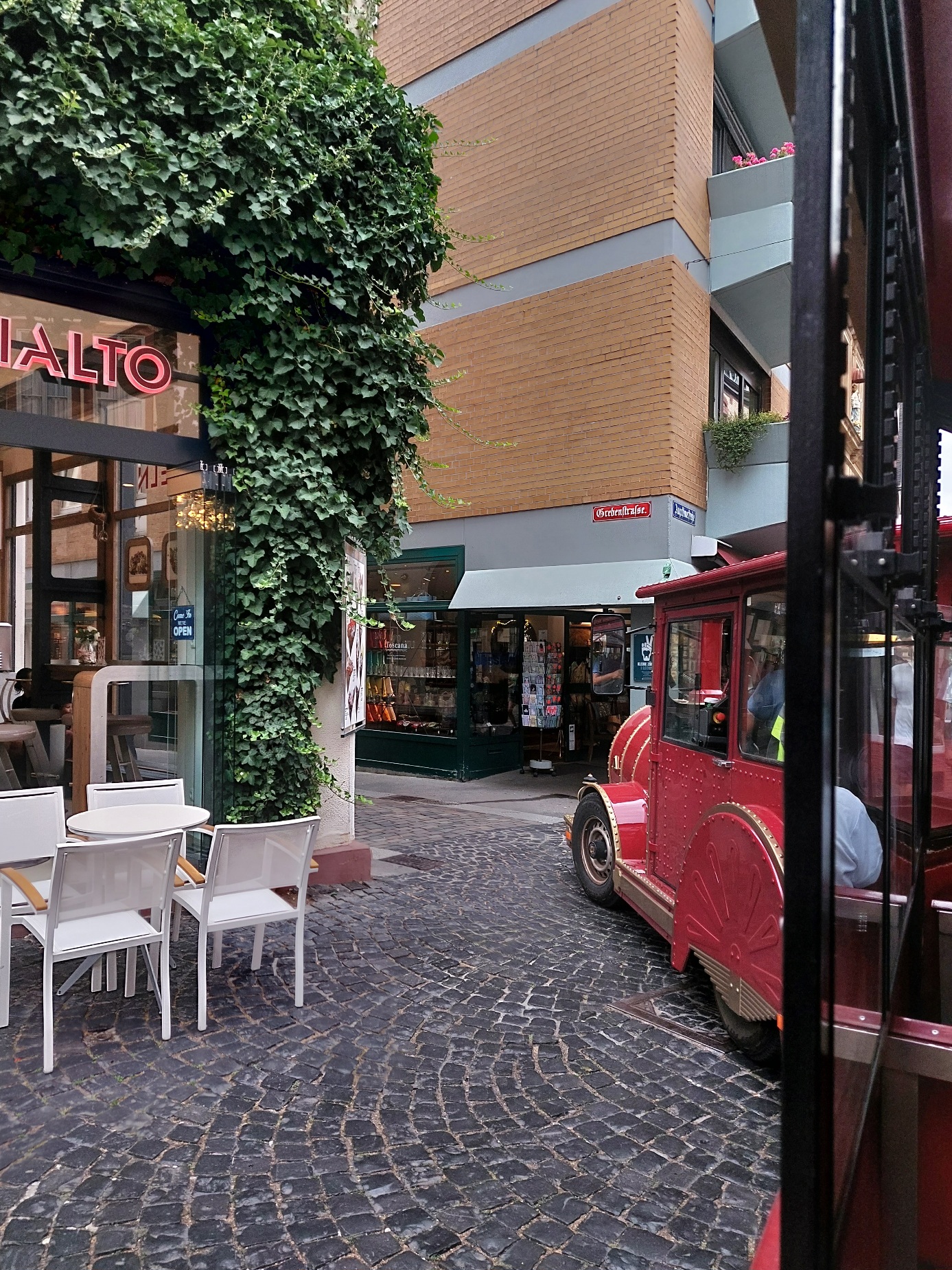Blick auf den roten „Gutenberg-Express“ in einer schmalen, kopfsteingepflasterten Gasse der Mainzer Altstadt